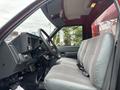 Interior view of a 2002 GMC C7500 featuring a gray upholstered driver's seat and a dashboard with various controls and gauges