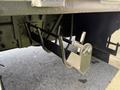 A metallic support bracket attached to a truck chassis with a rod and pin mechanism