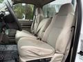 The interior of a 2008 Ford F-350 featuring two beige cloth seats with headrests and a steering wheel visible in the foreground