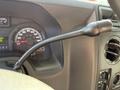 Close-up of the steering column and gear shift lever inside a 2012 Ford Econoline E-450 showing the speedometer and dashboard controls