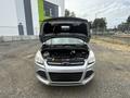 A silver 2014 Ford Escape with its hood raised showing the engine compartment