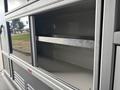 A spacious storage compartment of a 2020 Mercedes-Benz Sprinter 2500 with metal shelves and a clean interior design