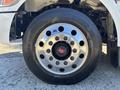 Close-up of a chrome wheel with multiple lug nuts and a black tire on a 2020 Peterbilt 330