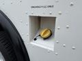 A fuel filler door with a yellow cap on a 2012 Ford E-450 Super Duty
