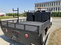 A 2005 GMC C7500 Topkick truck with a flatbed design featuring a metal mesh railing and various mounting options on the rear
