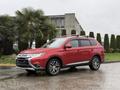 A red 2016 Mitsubishi Outlander parked with a shiny exterior and stylish alloy wheels