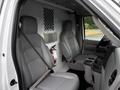 Two gray front seats of a 2017 Ford Econoline with seatbelts visible a console between the seats and a fire extinguisher mounted on the wall behind the driver's seat
