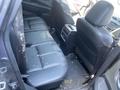 The interior of a 2017 Nissan Murano showing black leather back seats with stains and a central armrest console