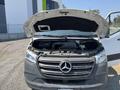 A 2022 Mercedes-Benz Sprinter van with its hood open revealing the engine compartment and various components inside