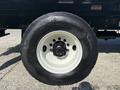 Close-up of a Michelin tire on a 2019 Freightliner M2 106 with a black wheel rim and white hubcap