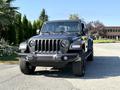 A black 2021 Jeep Gladiator with a prominent front grille and bold headlights parked on a driveway