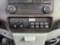 Control panel of a 2015 Ford F-350 featuring buttons for air conditioning, auxiliary controls, and a power take-off switch