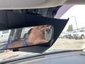 A 2022 Kia Sorento's interior rearview mirror is visible with a hand holding a smartphone reflected in it
