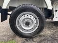 A close-up of the front tire and wheel of a 2008 Suzuki Carry featuring a silver rim and a black tire with visible tread patterns