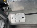 A silver diamond plate floor panel with two circular openings, set on a textured surface likely part of a 2006 E-One Typhoon fire truck interior