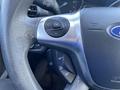 Close-up of the steering wheel of a 2016 Ford Escape featuring controls for audio and cruise settings
