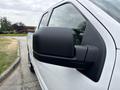 The image features a white 2018 Ford F-150 with a focus on its side mirror
