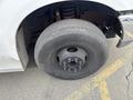 Close-up of a black tire mounted on a silver wheel of a 2004 Ford F-350 SD showing tire treads and wheel lug nuts