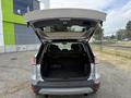 A 2015 Ford Escape with its rear hatch open revealing the spacious trunk area and two rear seats folded down