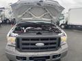 A 2005 Ford F-350 SD with its hood raised reveals the engine compartment showcasing various mechanical components and hoses