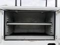 An empty cargo box of a 2020 Ford F-550 with two shelves and a metal frame inside
