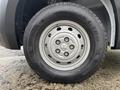 Close-up of a tire on a 2023 RAM Promaster 3500 showing a steel wheel with six circular openings and a tread design labeled Roadian CT8H