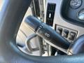 A close-up of the steering column of a 2020 Peterbilt 330 showing the turn signal and wiper controls on the left side
