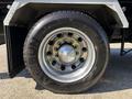 Close-up of a shiny chrome wheel of a 2020 Peterbilt 330 featuring a black tire with the brand name Arisun AT557 prominently displayed