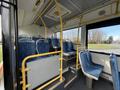 Interior of a 2016 Grande West Vicinity bus with blue patterned seats and yellow handrails in an empty seating area
