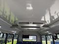 Interior view of a 2020 Chevrolet Express showing a smooth ceiling with a central air conditioning unit and rows of blue seats along the sides