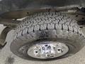 A close-up of a rugged tire mounted on a shiny chrome wheel showcasing deep treads designed for off-road traction