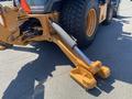 Close-up of a 2016 Case 580 Super N backhoe loader arm showing the hydraulic cylinder and stabilizer feet
