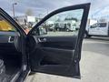 Inside a 2015 Dodge Durango with the front door open showcasing the door panel and interior features such as controls and trim