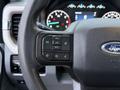 Close-up of a steering wheel from a 2023 Ford F-250 featuring control buttons for audio and cruise settings