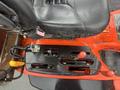 Close-up of the control panel of a 2010 Kubota F3680 featuring various levers buttons and a textured seat surface