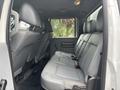 The interior of a 2014 Ford F-550 showing a spacious back seat with gray leather upholstery and a clean design