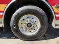 Close-up of a large tire mounted on a fire truck featuring chrome wheel rim and visible tread pattern with a brand logo