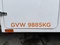 A white 2018 Ford F-550 with an orange label displaying GVW 9885KG