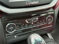 A close-up view of the climate control panel and gear shift in a 2016 Maserati Ghibli featuring buttons for air conditioning and fan settings