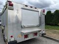 A 2010 Ford F-550 Super Duty truck with a metallic diamond plate rear and a roll-up shutter door