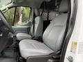 Interior view of a 2019 Ford Transit showing two gray leather front seats and part of the driver's console
