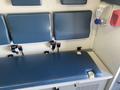 2011 Chevrolet Express interior with a blue padded bench seat and wall-mounted storage compartments