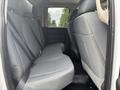 The interior of a 2016 RAM 1500 showing the rear seating area with gray fabric upholstery and seat belts