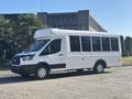 A white 2017 Ford Transit-350 passenger van with large windows and a high roof parked in a lot facing left