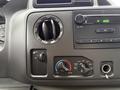 Dashboard controls of a 2013 Ford Econoline featuring air conditioning knobs and a radio interface
