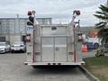 A 2002 GMC C7500 fire truck featuring a silver metallic body with red lights and a storage compartment on the rear