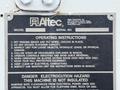 A metal sign with operating instructions for an Altec model1270, detailing safety protocols, equipment maintenance, and hazard warnings related to a 2005 Freightliner M2 106