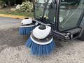 A 2019 Madvac LS175 street sweeper with two large blue bristle brushes attached at the front designed for cleaning surfaces