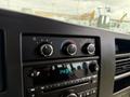 Close-up of the dashboard controls in a 2013 Chevrolet Express featuring climate control knobs and a digital clock display