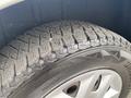 Close-up of a tire on a 2014 RAM Cargo Van showing deep tread patterns and a sturdy build designed for durability and traction